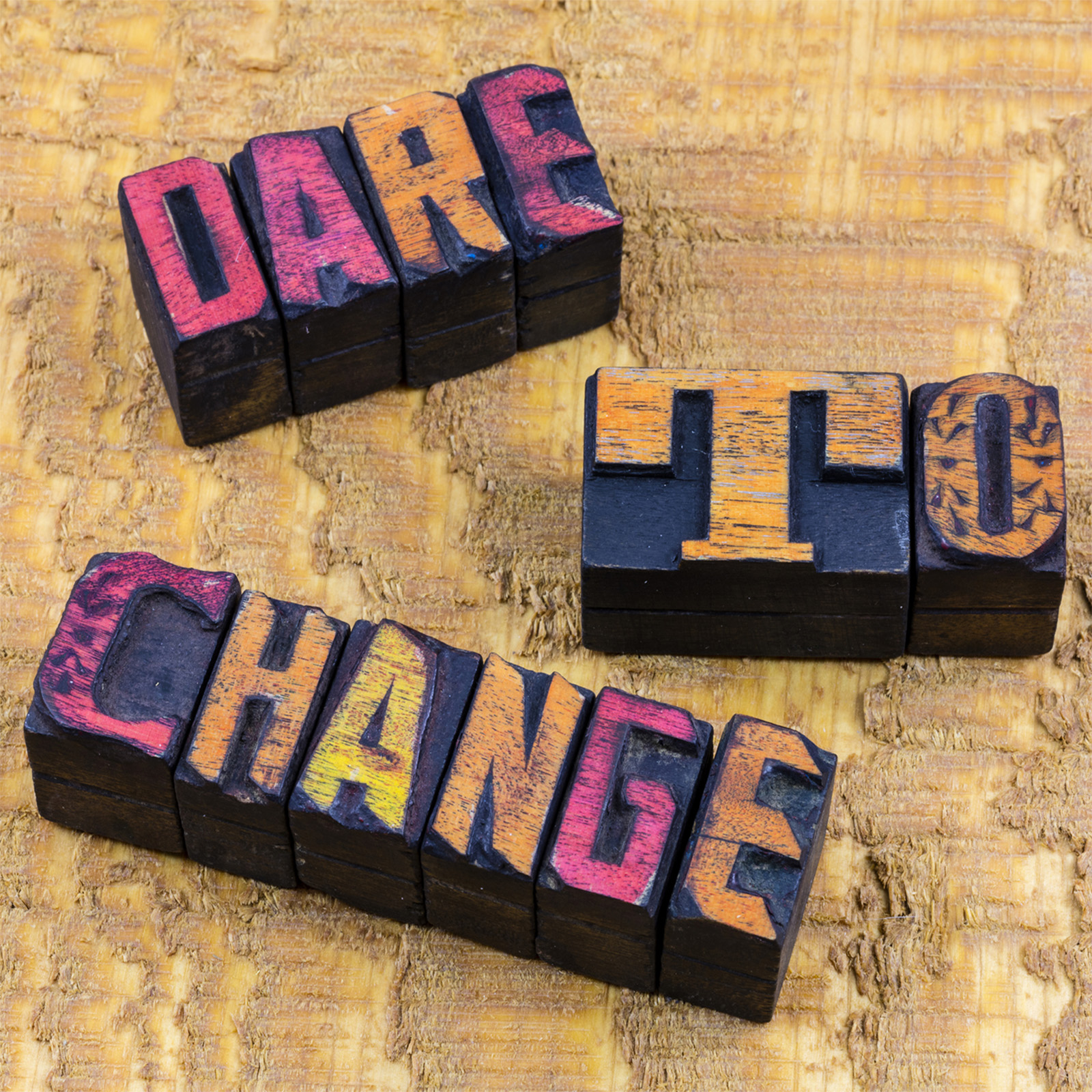 Yellow, bright pink and orange letters spelling dare to change.